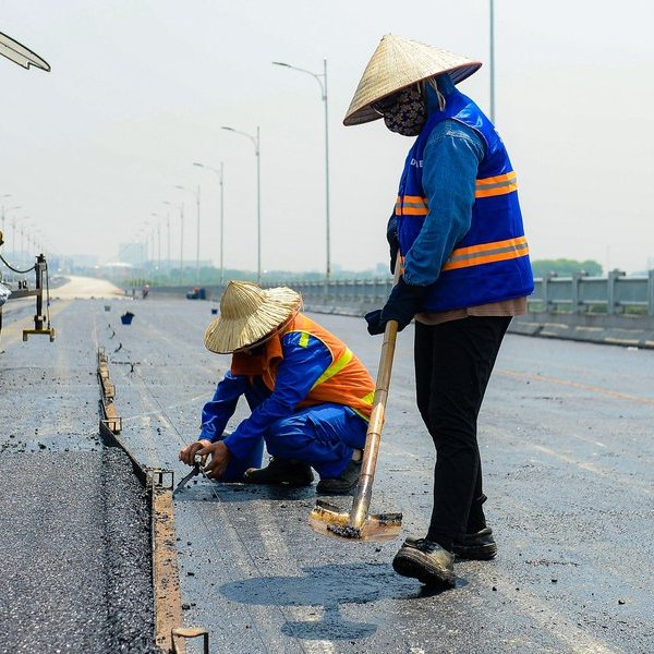 Công nhân đội nắng trải thảm nhựa cầu Vĩnh Tuy 2